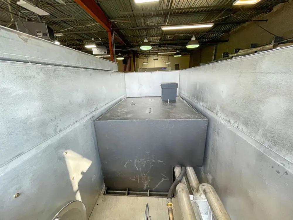 Exterior view of small fire truck showing cab, body compartments, and wheel/tire area.